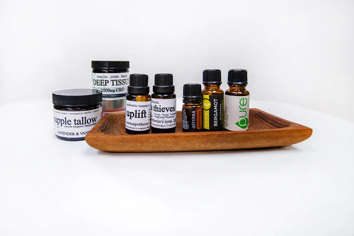 A wooden tray holding several small essential oil bottles.