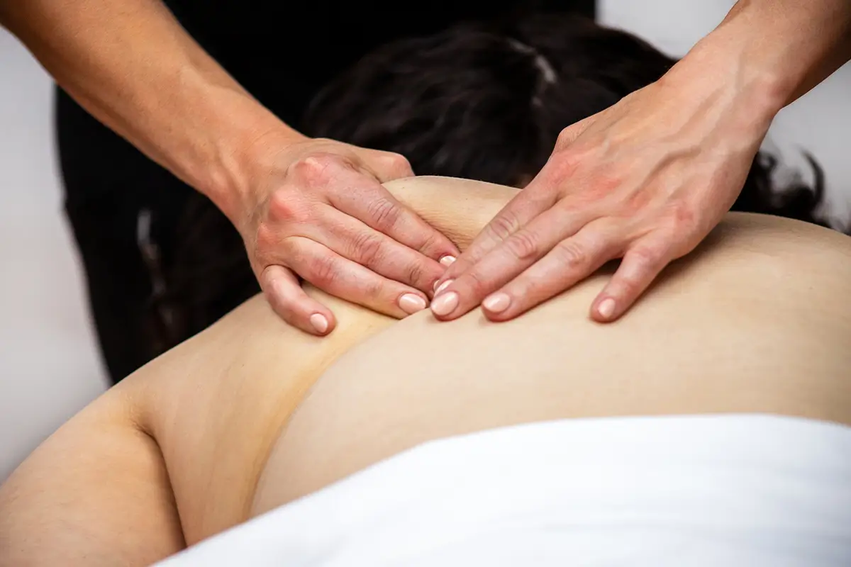 A close-up photograph of a massage therapist's hands 